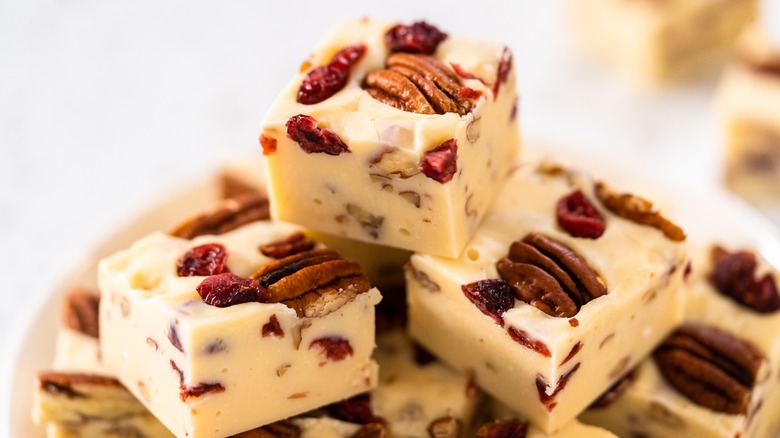 Stack of wite chocolate fudge with pecans and cranberries