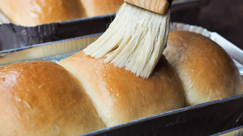 Brushing butter on bread rolls