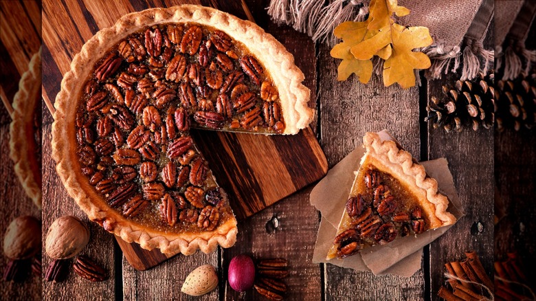 pecan pie and slice on wooden surface