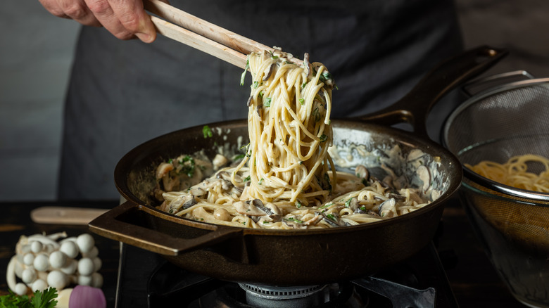 person serving pasta from pot