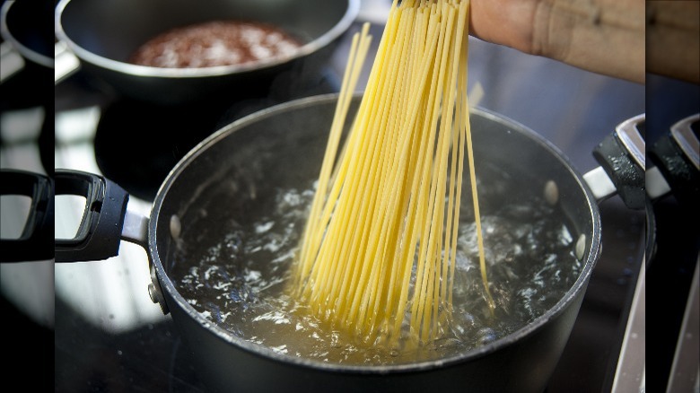 dry spaghetti in boiling water