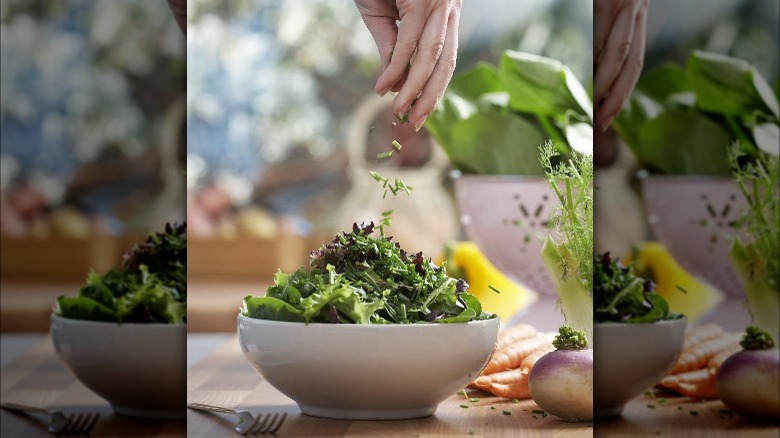 adding fresh herbs to salad