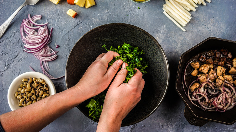 massaging kale leaves over bowl