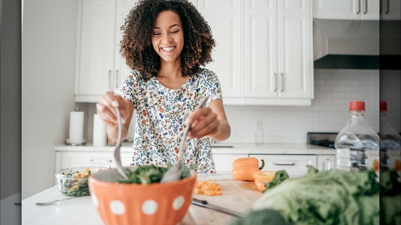 woman tossing salad in bowl