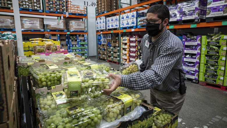 man buying big container of grapes