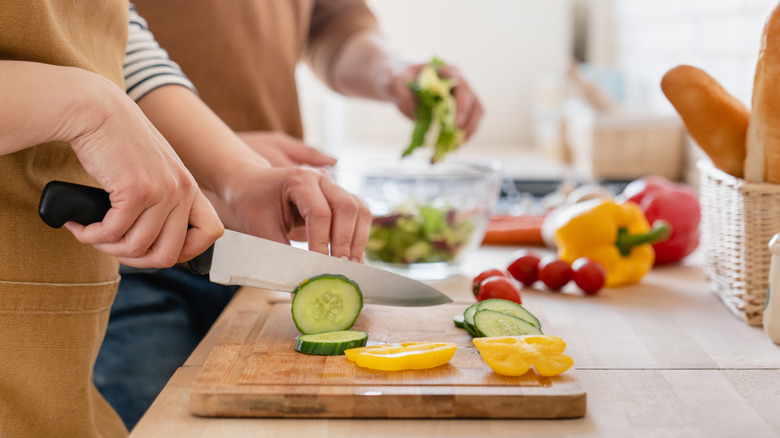 slicing veggies on wooden board