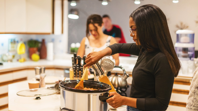 woman stirring food in cooker