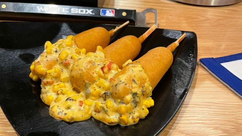 Three corn dogs with sauce