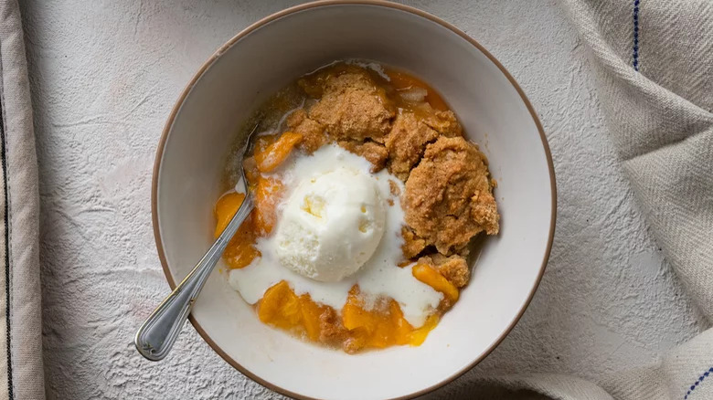 bowl of peach cobbler and ice cream