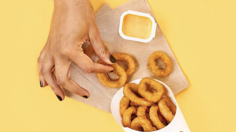 grabbing onion rings and Zesty sauce