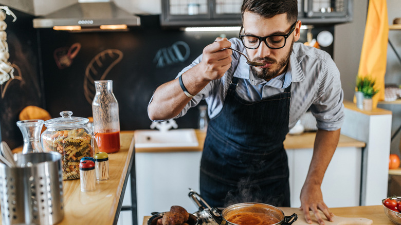 Man tasting soup with spoon