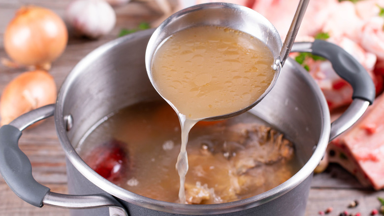 Homemade stock pouring from ladle