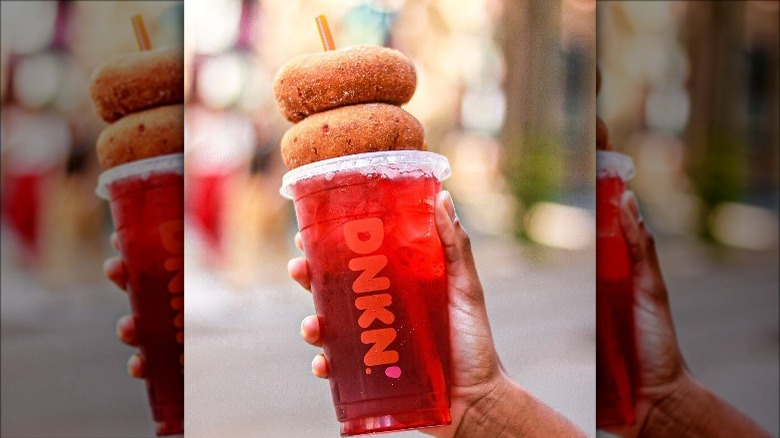 Red iced drink with two donuts stacked atop