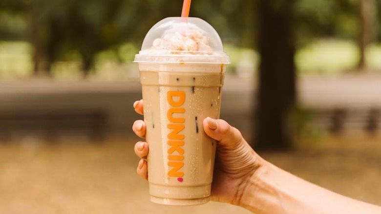 Holding Dunkin iced coffee with whipped cream