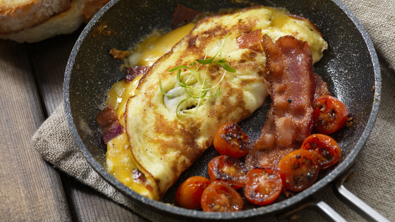 Skillet with omelet and bacon