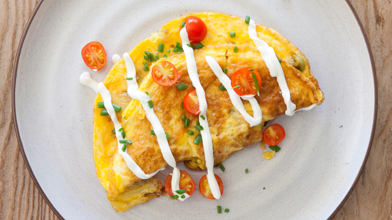 Sour cream drizzled on omelet