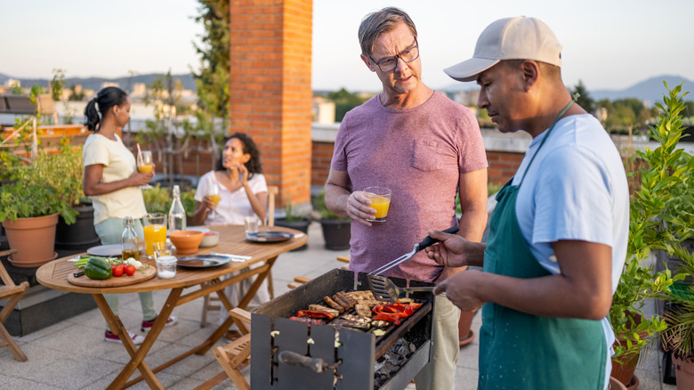 people standing outside by grill