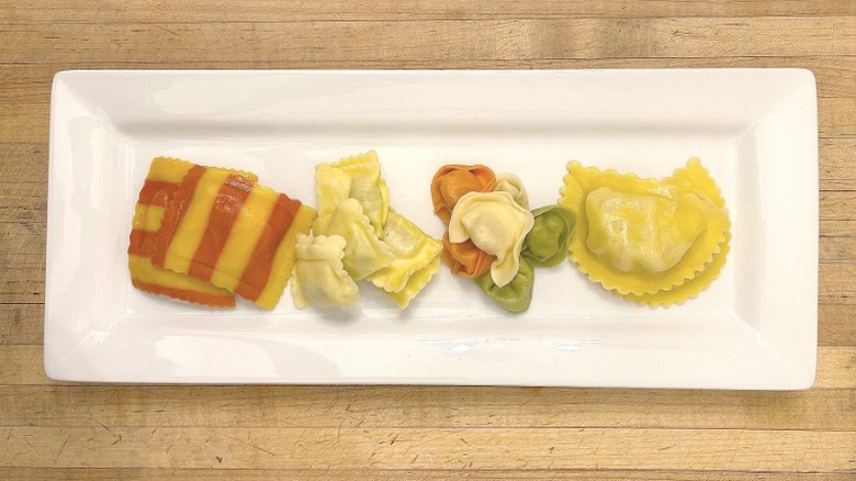 Rectangular white plate with lobster ravioli, ricotta and spinach ravioli, tri-color cheese tortellini, and Italian sausage ravioli