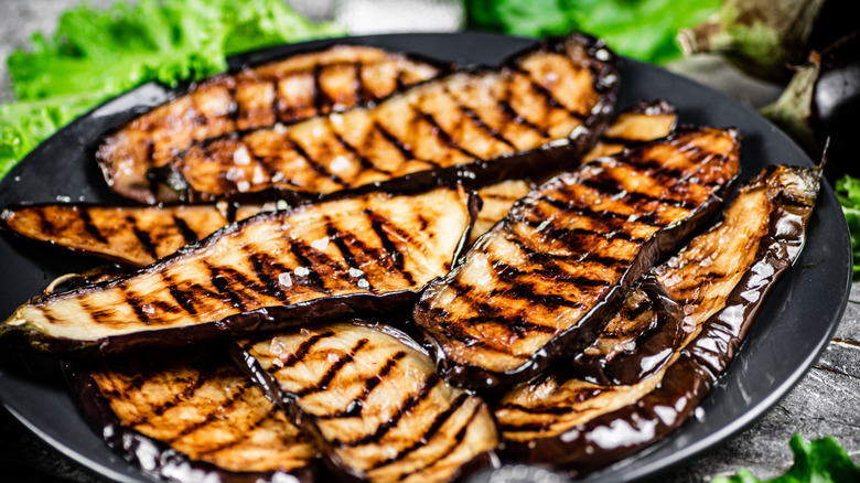 thin, wide slices of grilled eggplant on black serving plate