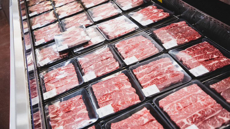 An assortment of packaged meat in the meat section of a grocery store