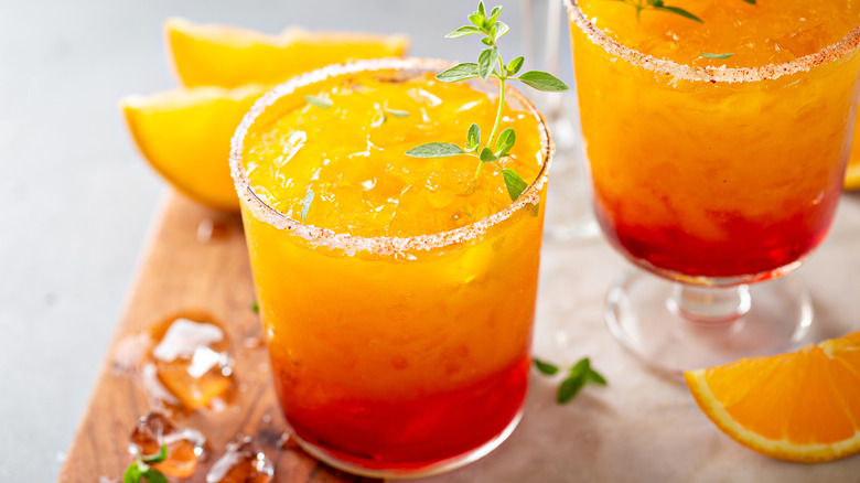 Vibrant orange and red tequila-based cocktail with salt and spice rim