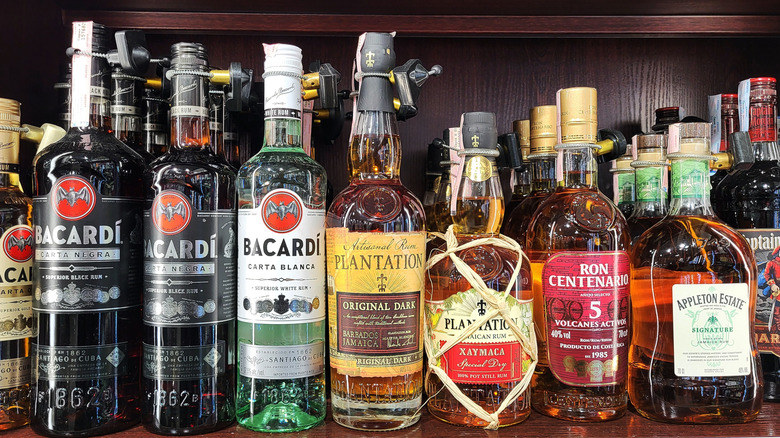 Variety of rum brands on a dark wood shelf