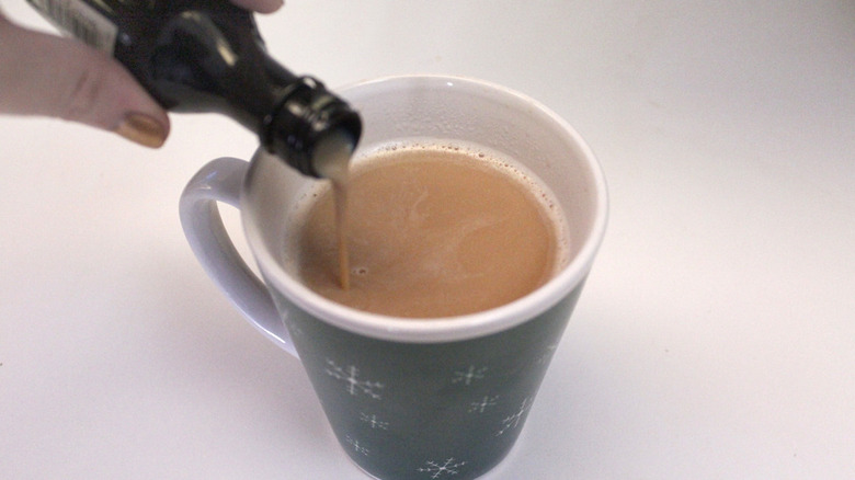 pouring Baileys into a mug