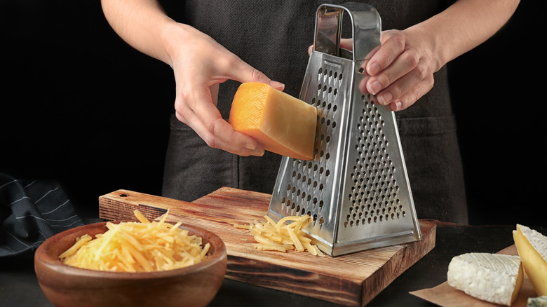 grating cheese on cutting board