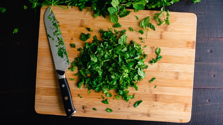 Cutting board with knife and herbs