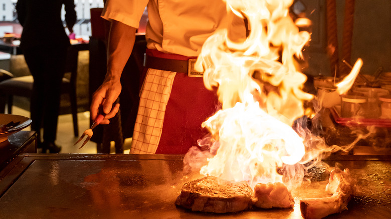 Chef cooking teppanyaki-style steak