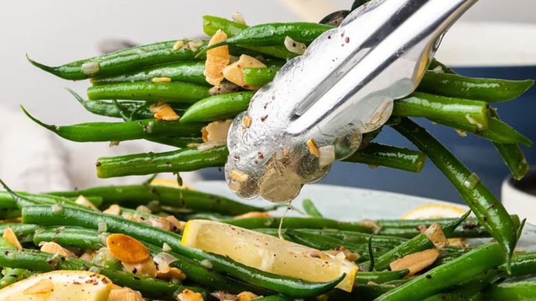 green beans held in tongs