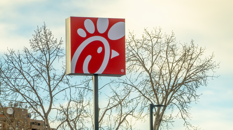 A Chick-fil-A sign at a location in Calgary, Alberta, with barren trees in the cold background