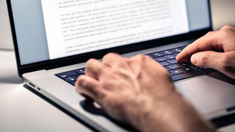 Hands writing on laptop