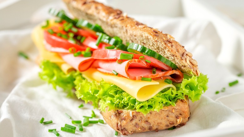 sandwich with vegetables and meat on seeded bread