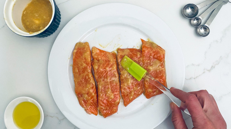 applying honey mustard to salmon