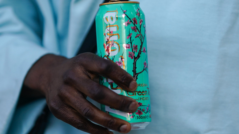 hand holding AriZona tea can