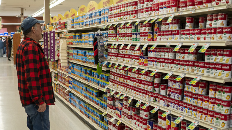 man shopping for canned soups