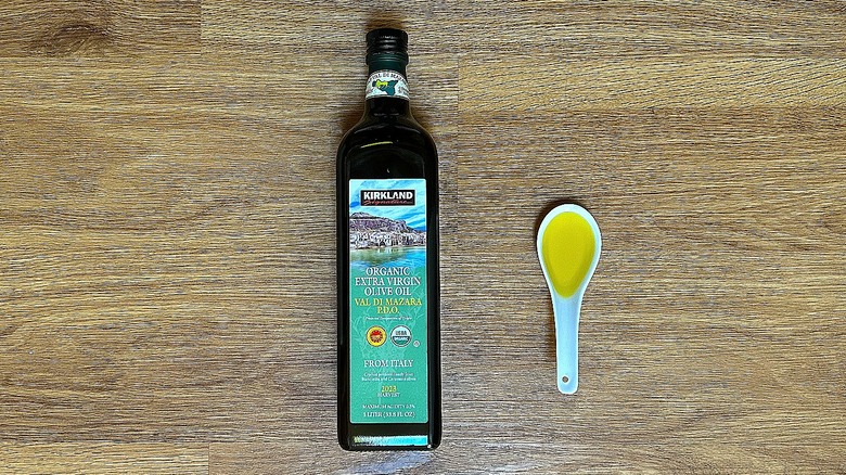 Bottle and spoonful of Kirkland Signature Organic Extra Virgin Olive Oil Val Di Mazara P.D.O.