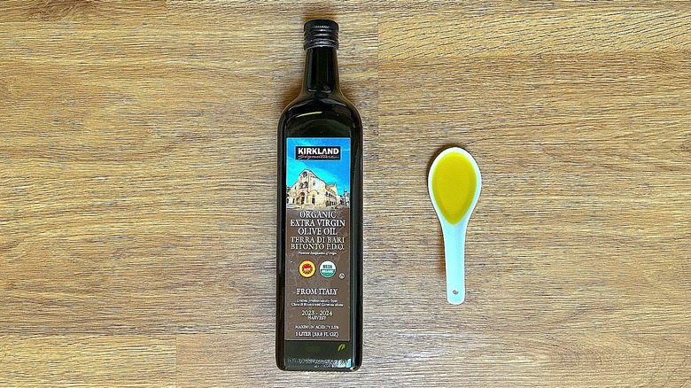 Bottle and spoonful of Kirkland Signature Organic Extra Virgin Olive Oil Terra Di Bari Bitonto P.D.O.