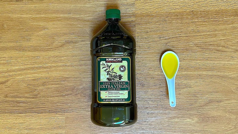 Bottle and spoonful of Kirkland Signature 100% Italian Extra Virgin Olive Oil