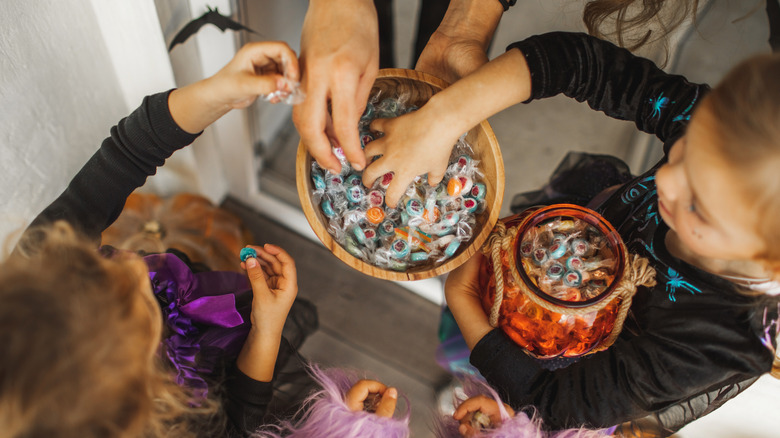 Kids grabbing candy from bowl