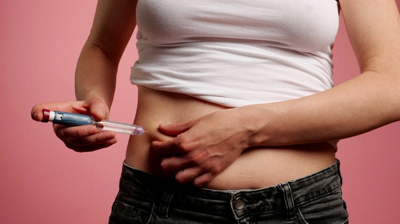 woman injecting insulin in stomach