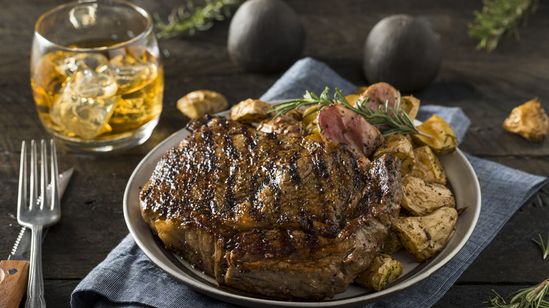 steak on plate with cocktail in background