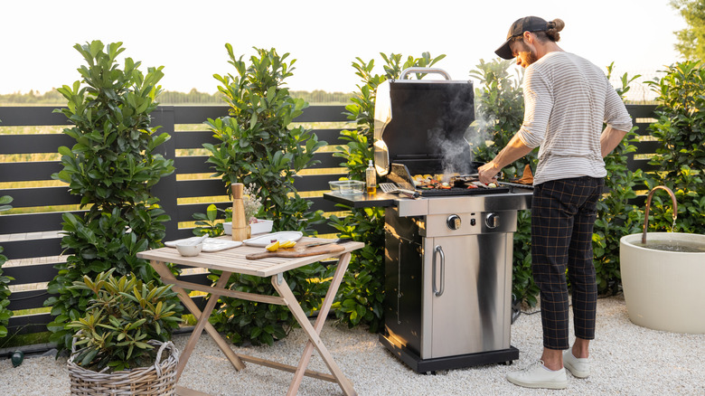 Man grilling surrounded by plants