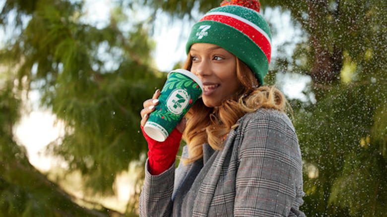 Person in 7-Eleven beanie drinking Winter Wonderland Cocoa