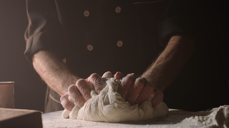 person making pasta dough