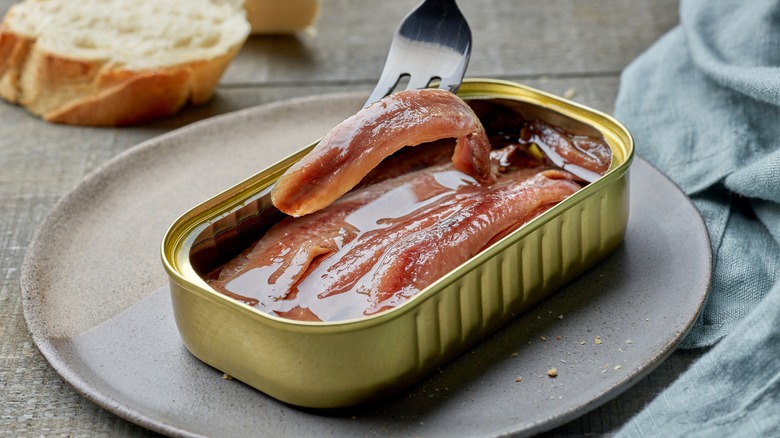 a tin of anchovies on a plate