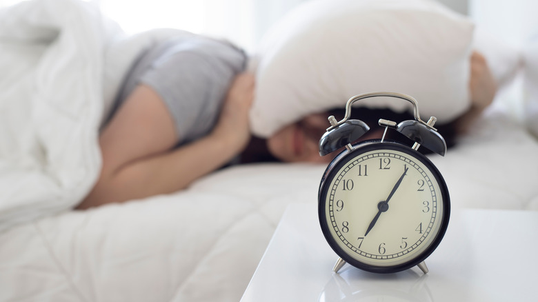 women covering head with pillow