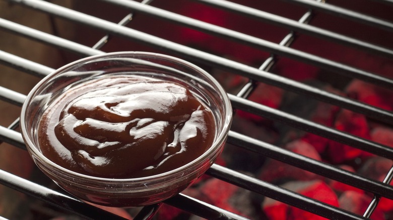 Small bowl of BBQ sauce on grill