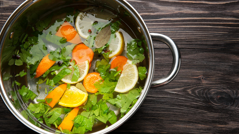 pot with herbs, lemons, and oranges for brine